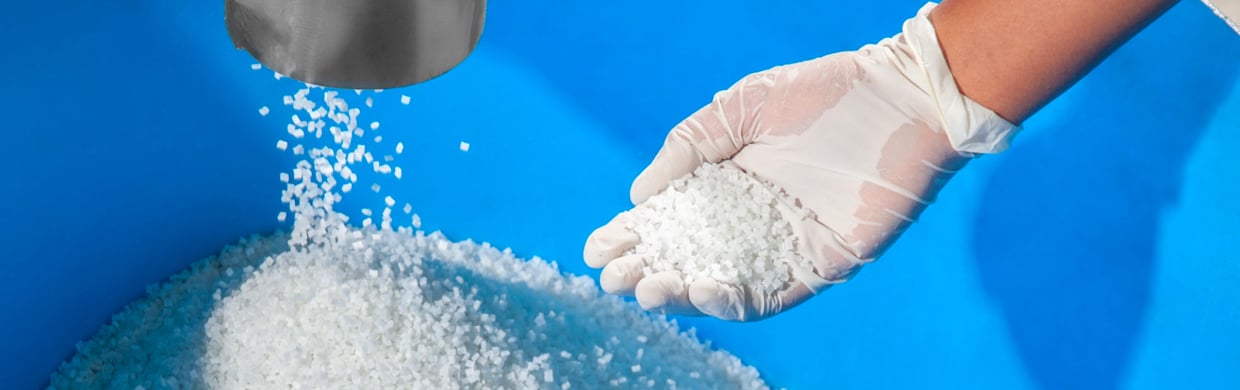 Worker holding pellets made from recycled plastic